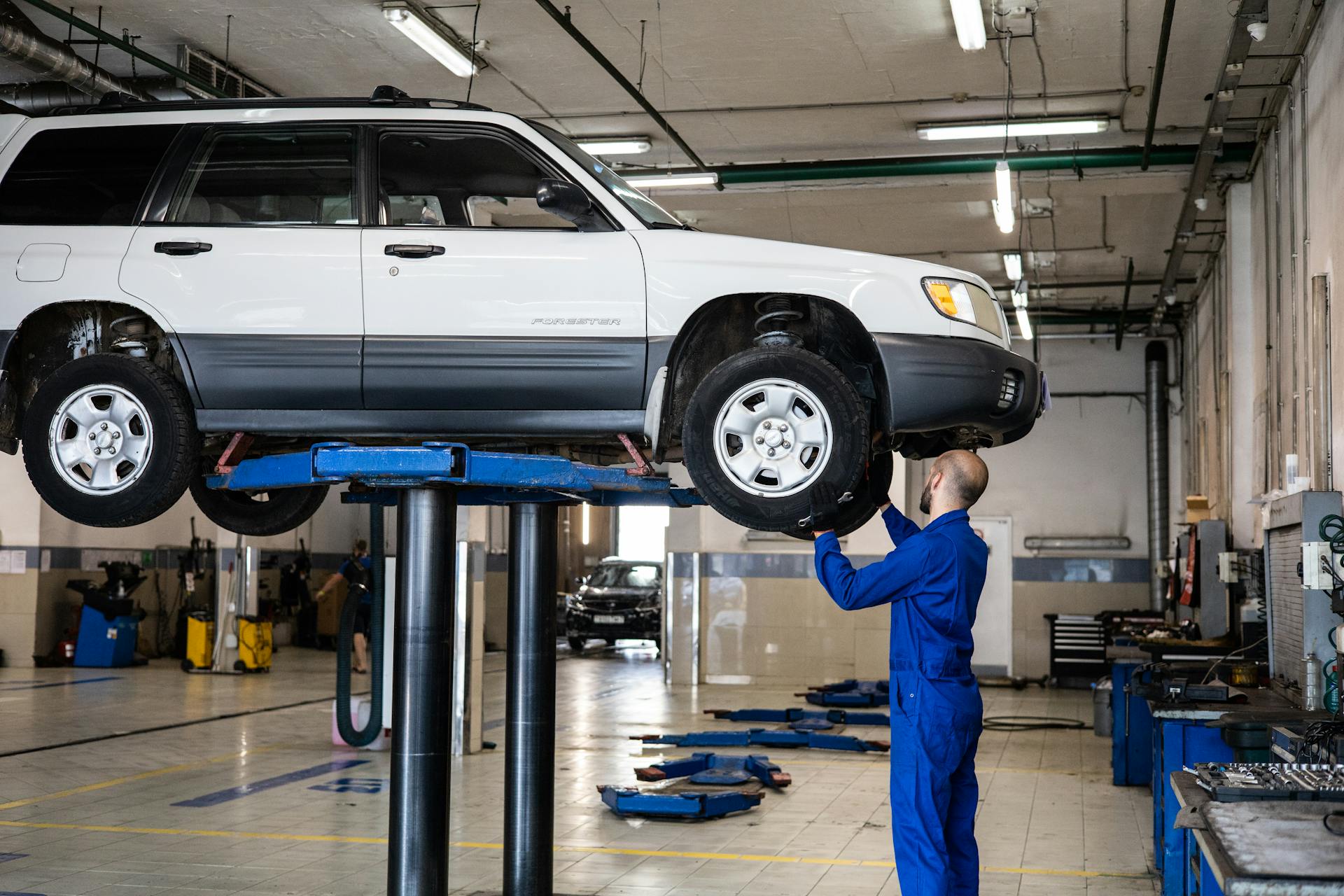 Mechanic inspecting vehicle on lift at Pro Automotive Repair in Sachse TX