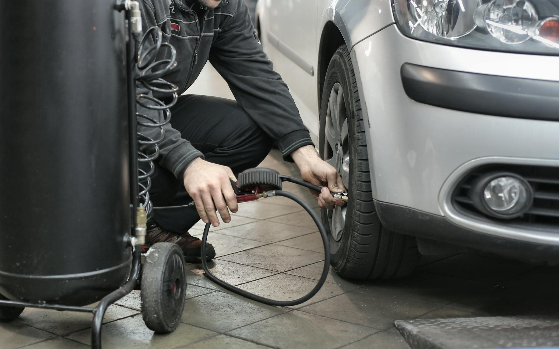 Mechanic servicing vehicle AC system at Pro Automotive Repair