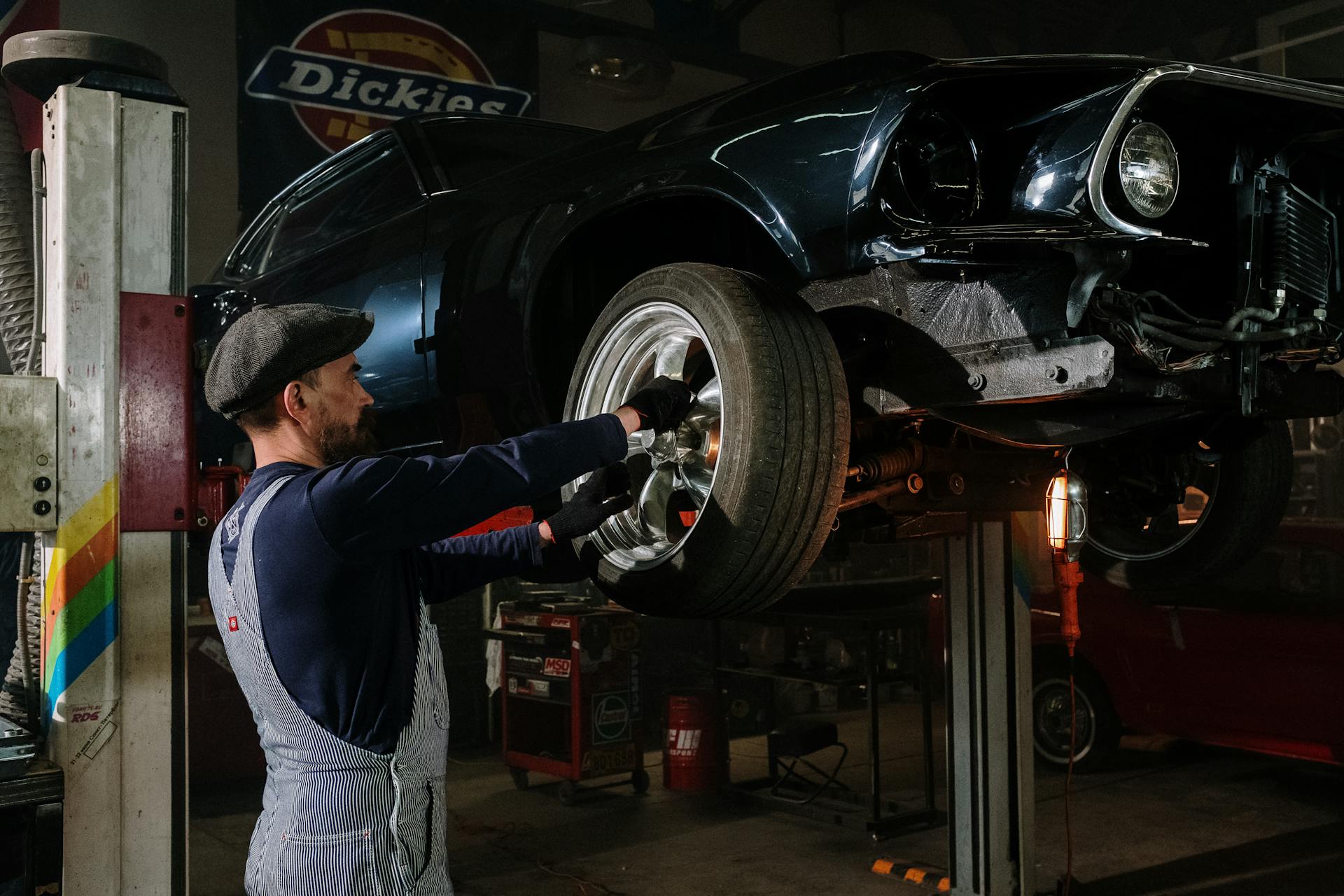 Mechanic working on vehicle suspension components on lift